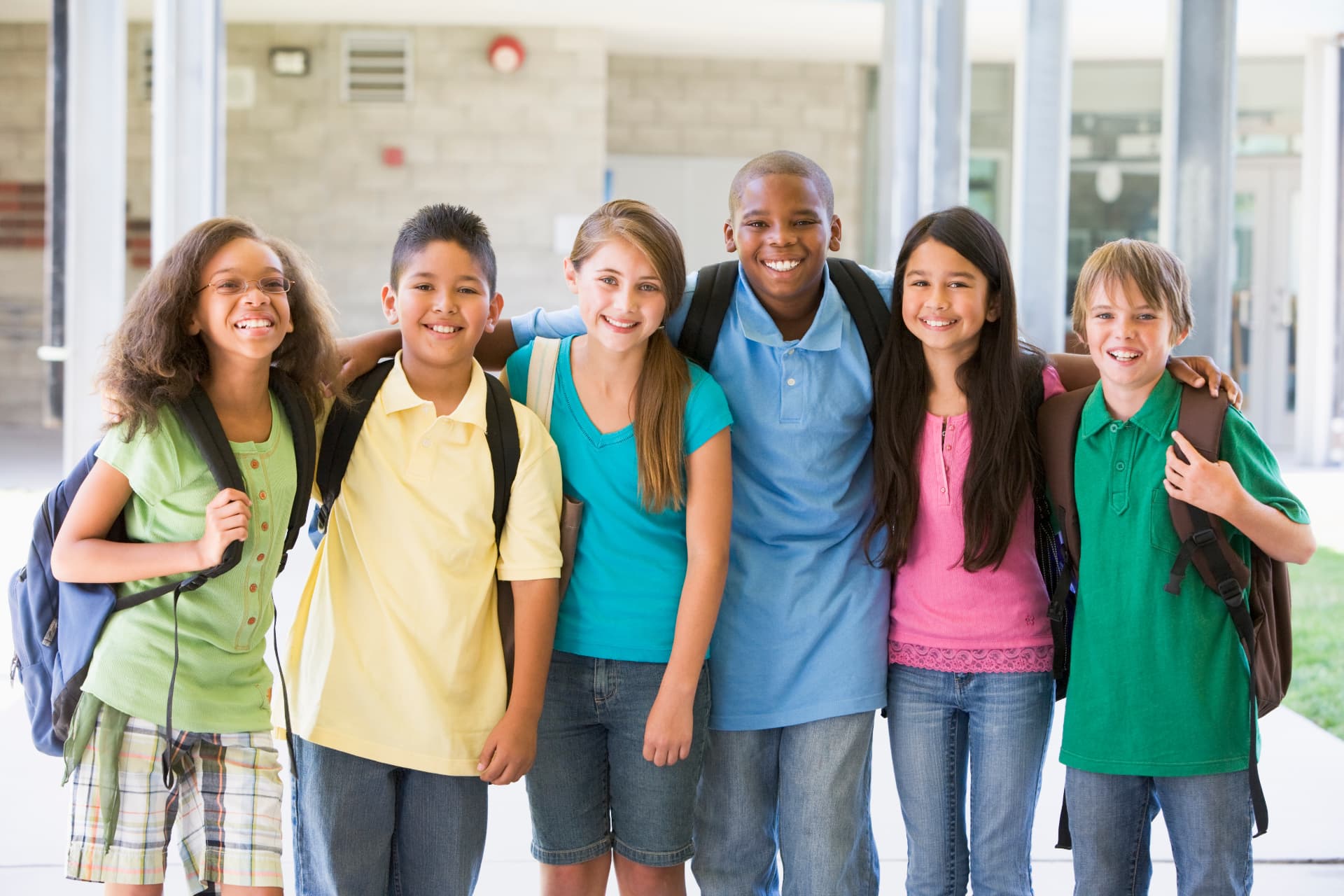 Stock photo of a group of smiling middle school students with backpacks